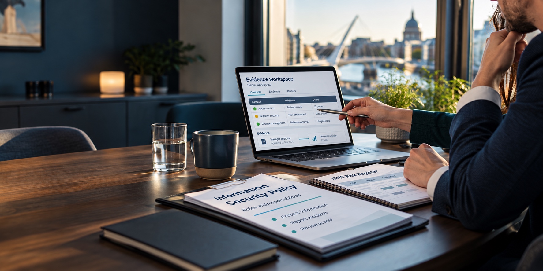 Consultation reviewing a demonstration GRC evidence workspace beside an Information Security Policy and ISMS Risk Register